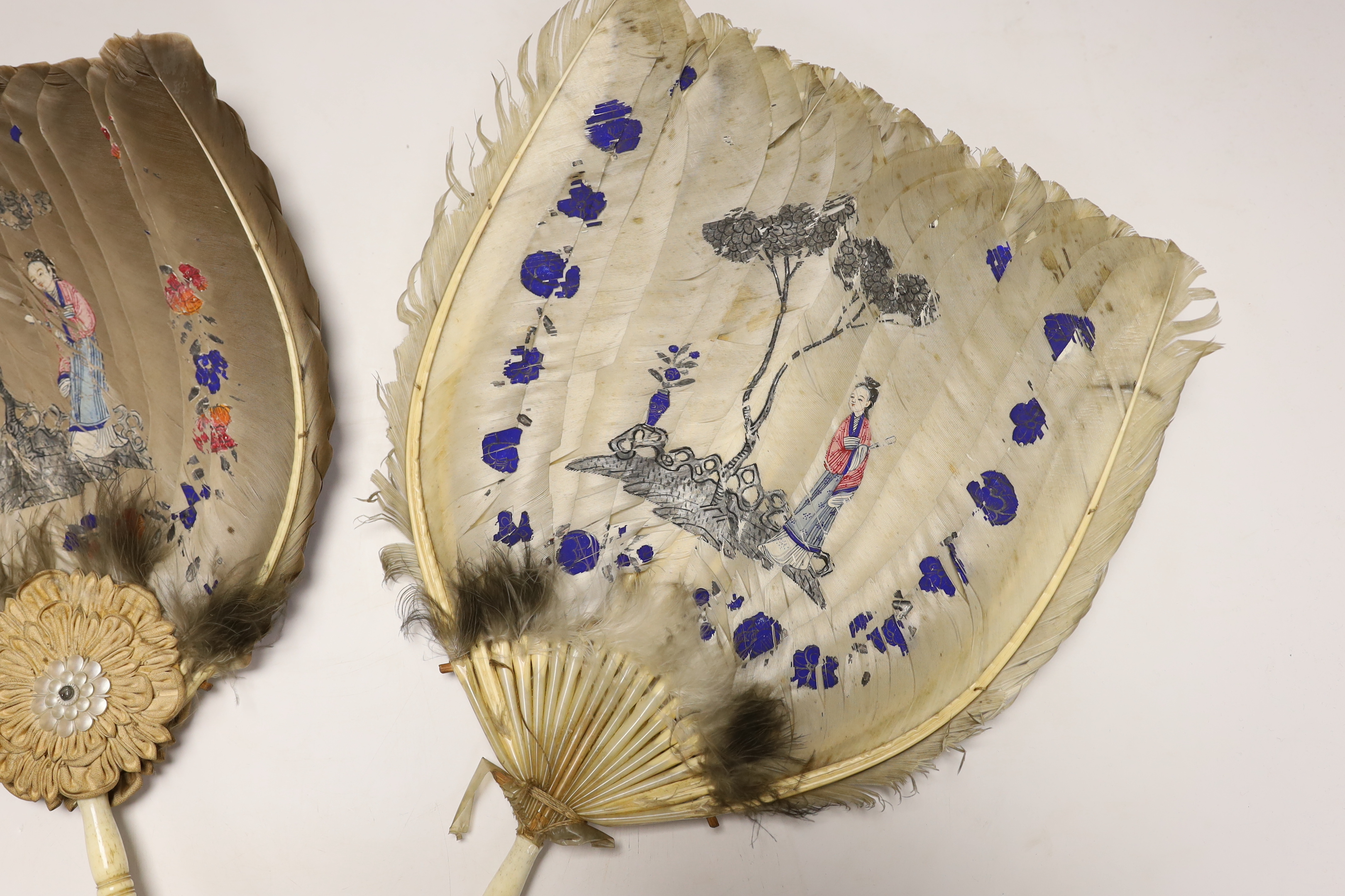 Two feather and bone handled Regency feather fans, the feathers hand painted with Chinese figures one side and flowers the other, one fan has silk rosettes with mother of pearl and feather ornamentation to the top of the